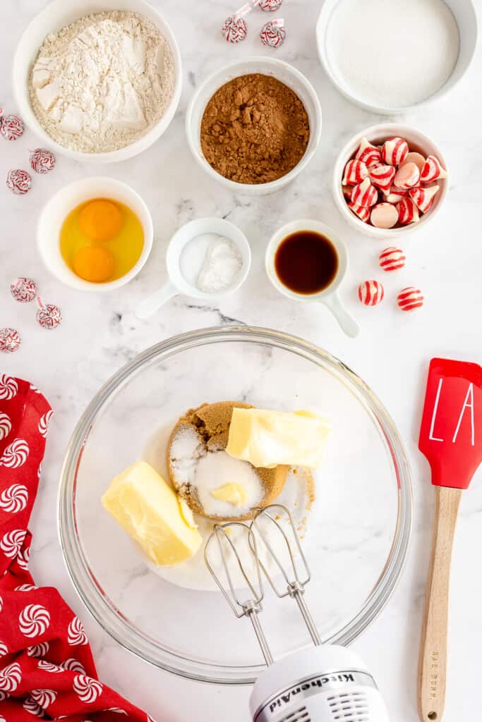 Glass mixing bowl with hand mixer mixing butter and sugars