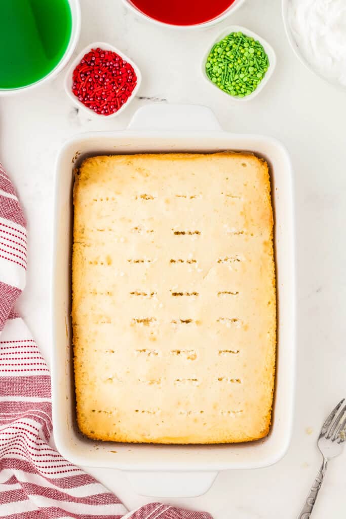 Overhead image of white cake with holes in it for poke cake