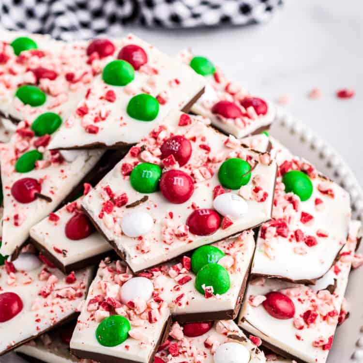 Pieces of peppermint bark on plate with navy check napkin in background