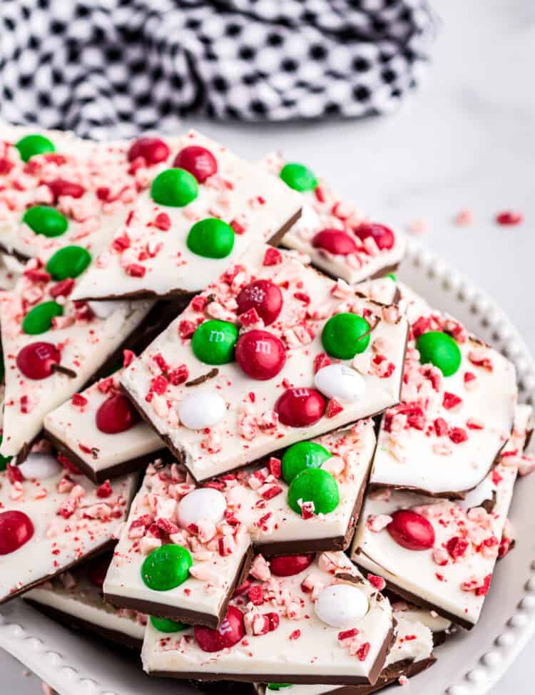 Pieces of peppermint bark on plate with navy check napkin in background