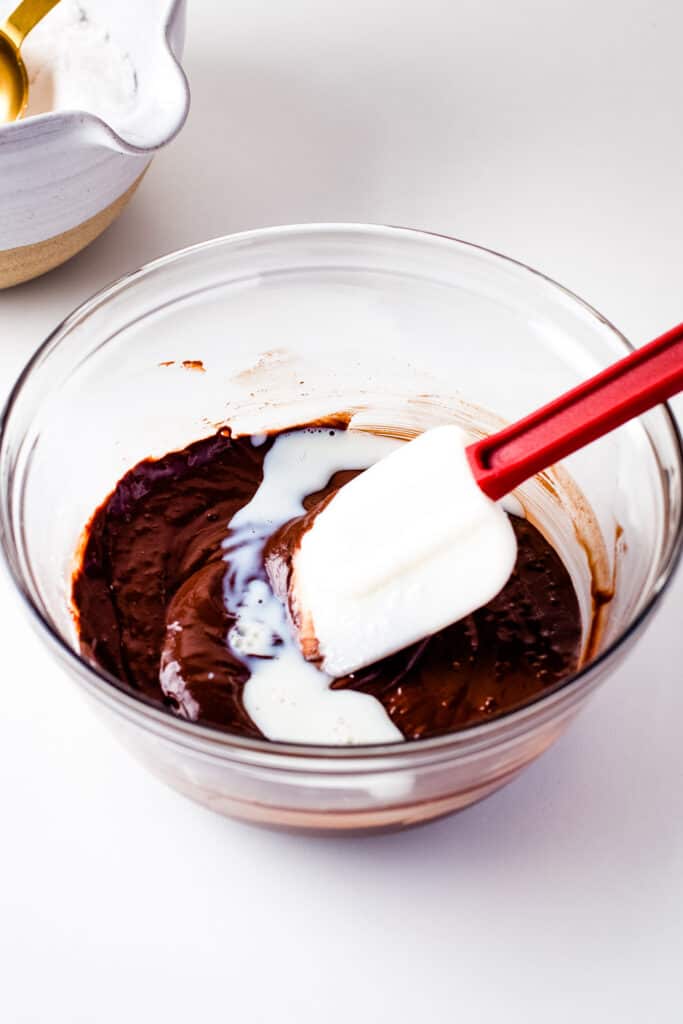 Mixing milk into chocolate frosting