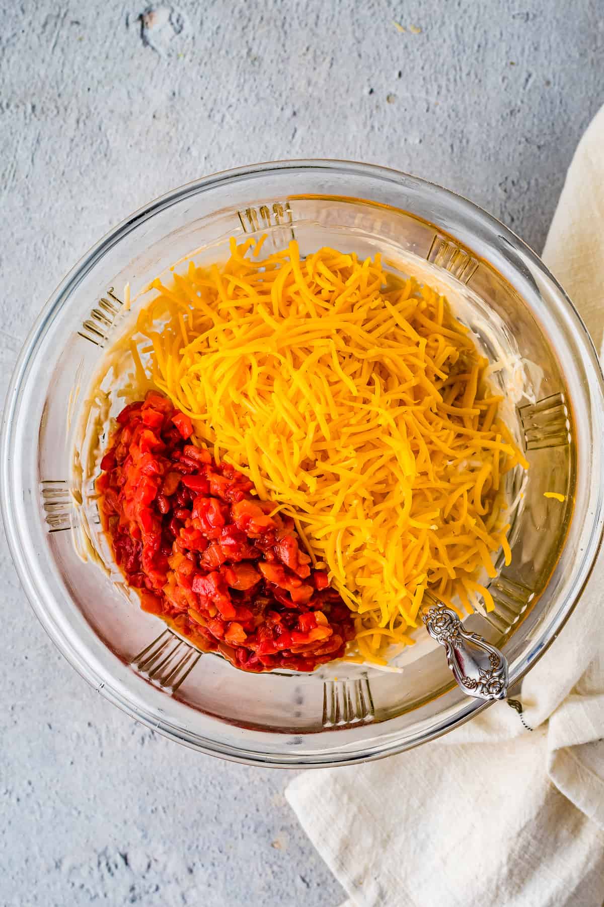 Overhead image of cheese and pimentos in glass bowl