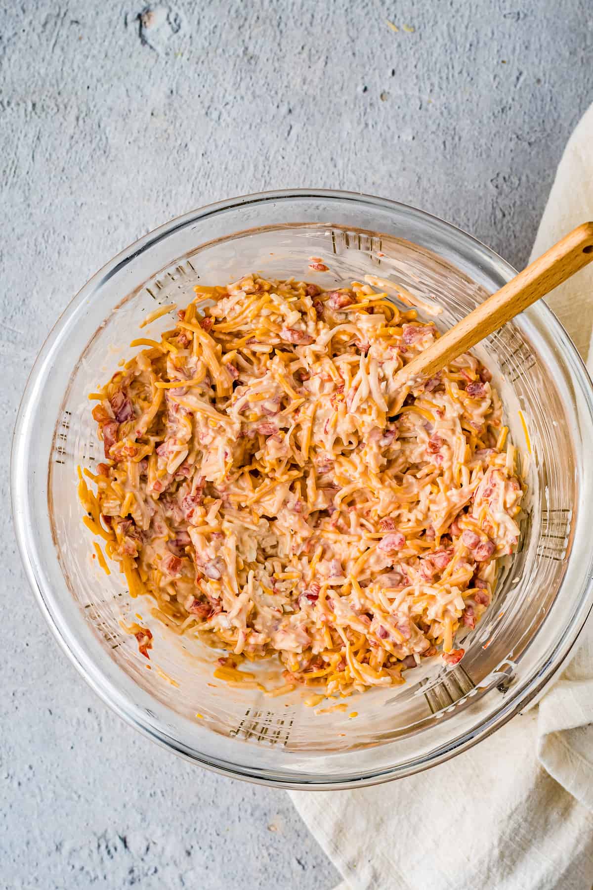 Overhead image of wooden spoon in a bowl of pimento cheese