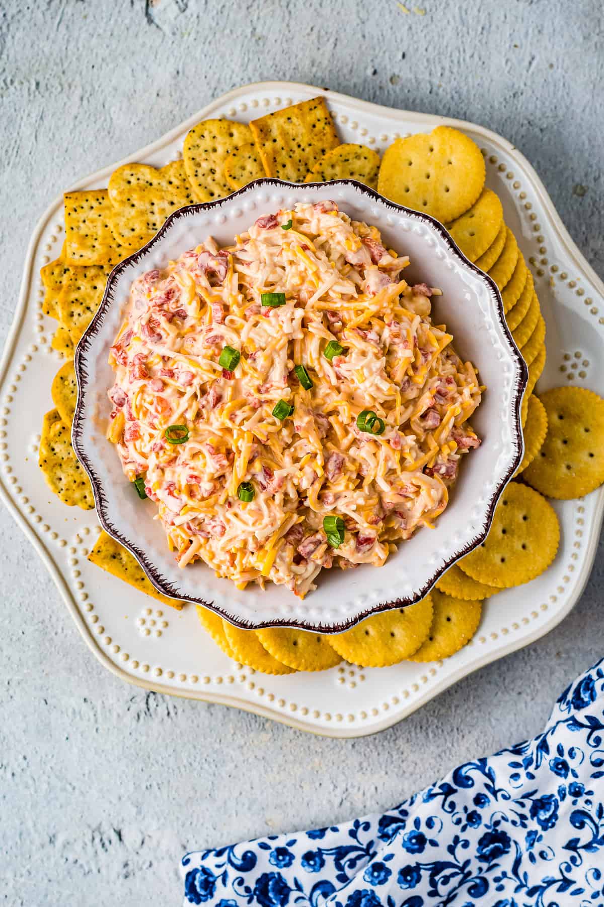 Overhead image of pimento cheese in bowl with crackers on plate