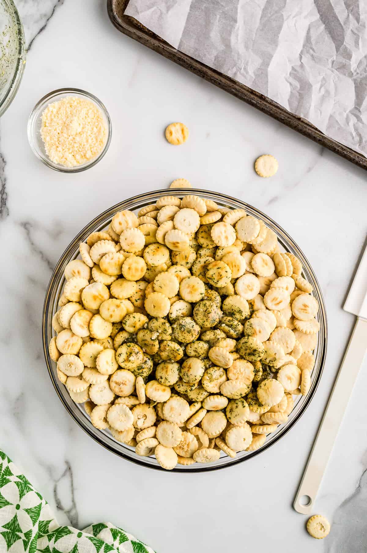 Glass bowl of oyster crackers with seasoned butter on top