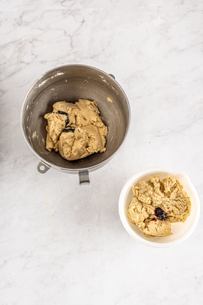 Cookie dough divided into two bowls with red and green food coloring