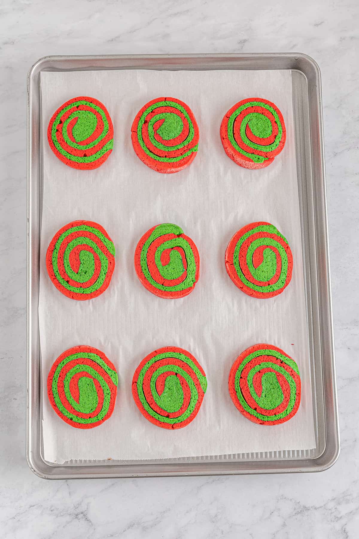 Baked Christmas pinwheel cookies sliced and on baking sheet