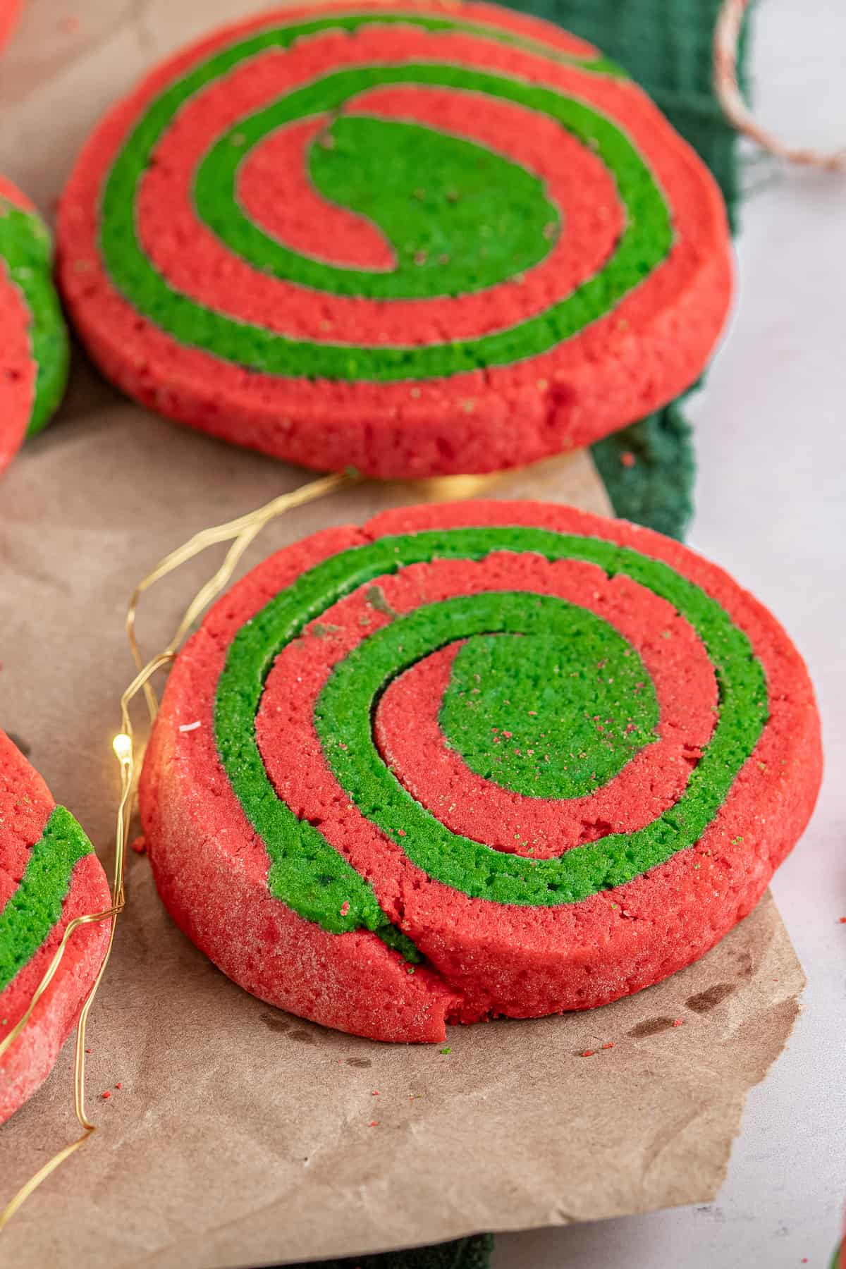 Red and Green Pinwheel Cookies on brown parchment paper
