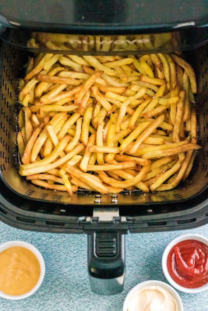 Air Fryer Basket with cooked frozen French Fries in it