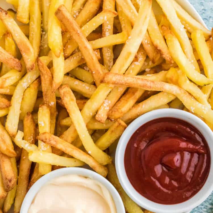 Overhead image of French Fries with bowls of sauce and ketchup