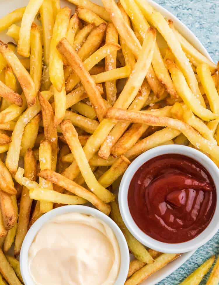 Overhead image of French Fries with bowls of sauce and ketchup