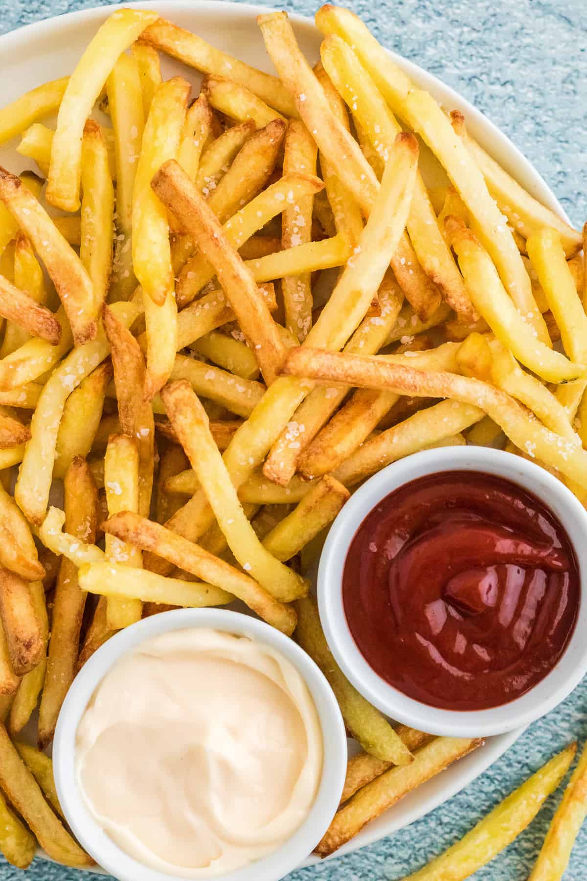 Overhead image of French Fries with bowls of sauce and ketchup