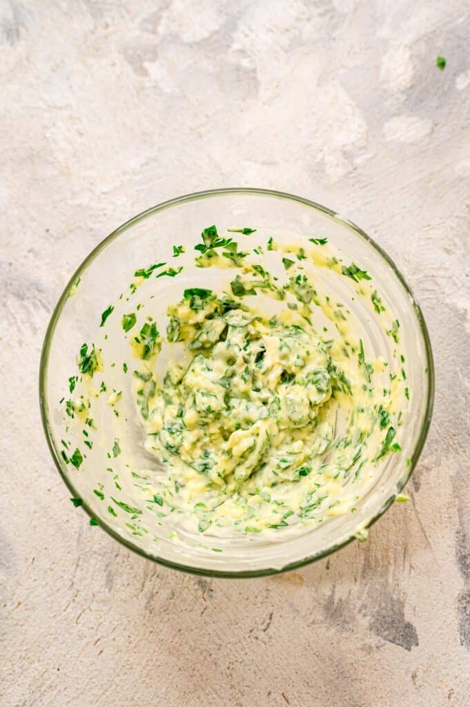 Small glass bowl with butter, parsley and garlic mixed up