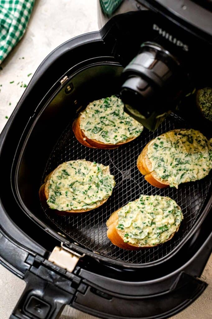 Homemade pieces of garlic bread in air fryer before toasting