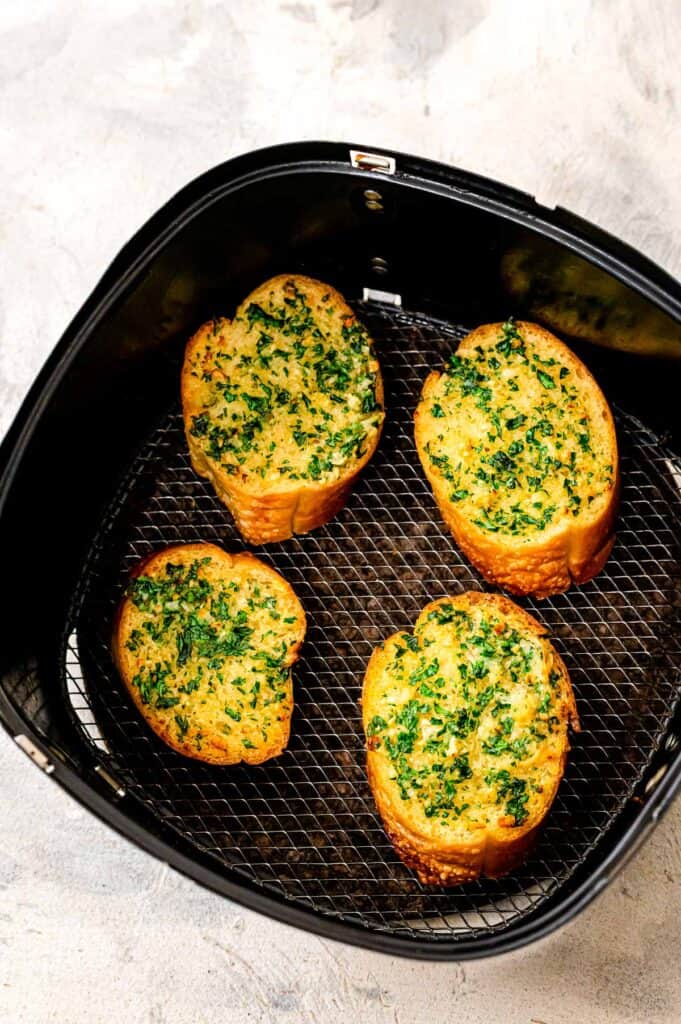 Homemade pieces of garlic bread in air fryer after toasting
