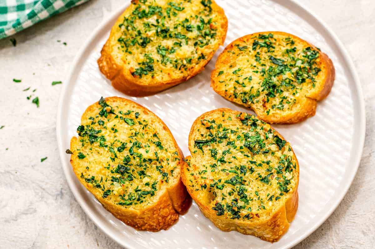 White plate with four pieces of Air Fryer Garlic Bread