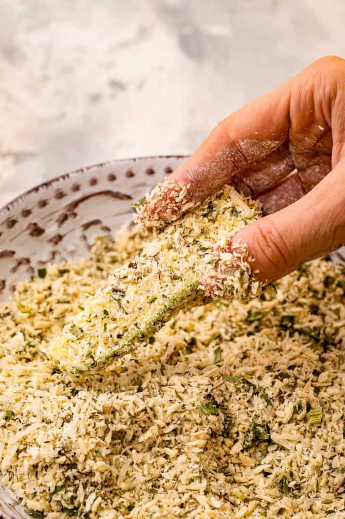 Hand breading a zucchini fry