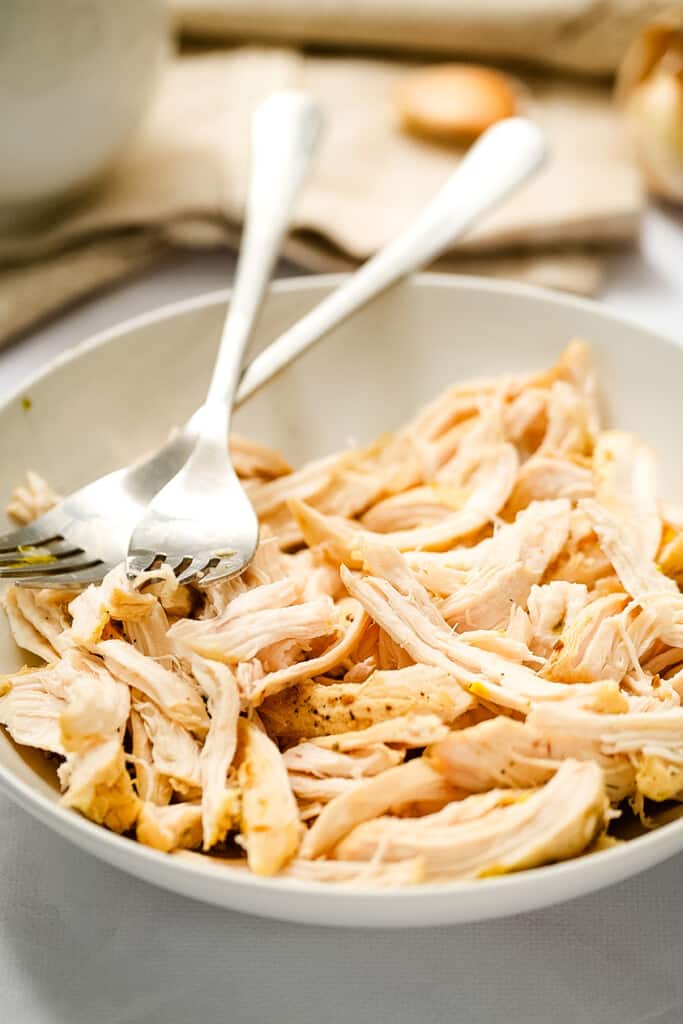 Forks shredded chicken breasts in bowl