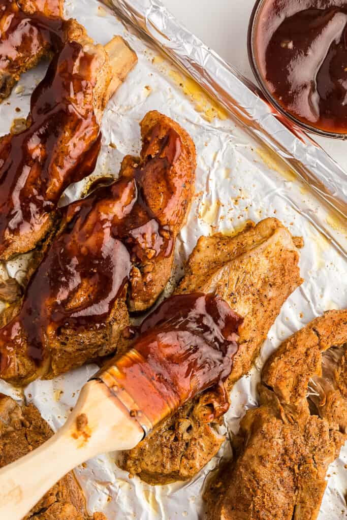 Brushing country style ribs with BBQ sauce