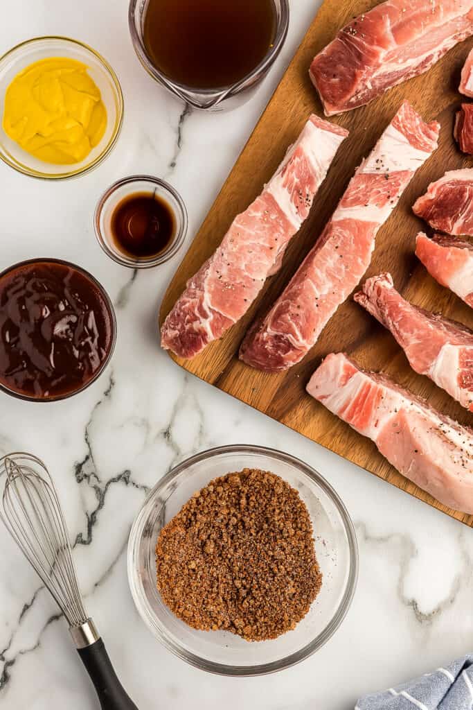 Rib rub mixed in glass bowl with country style ribs ingredients