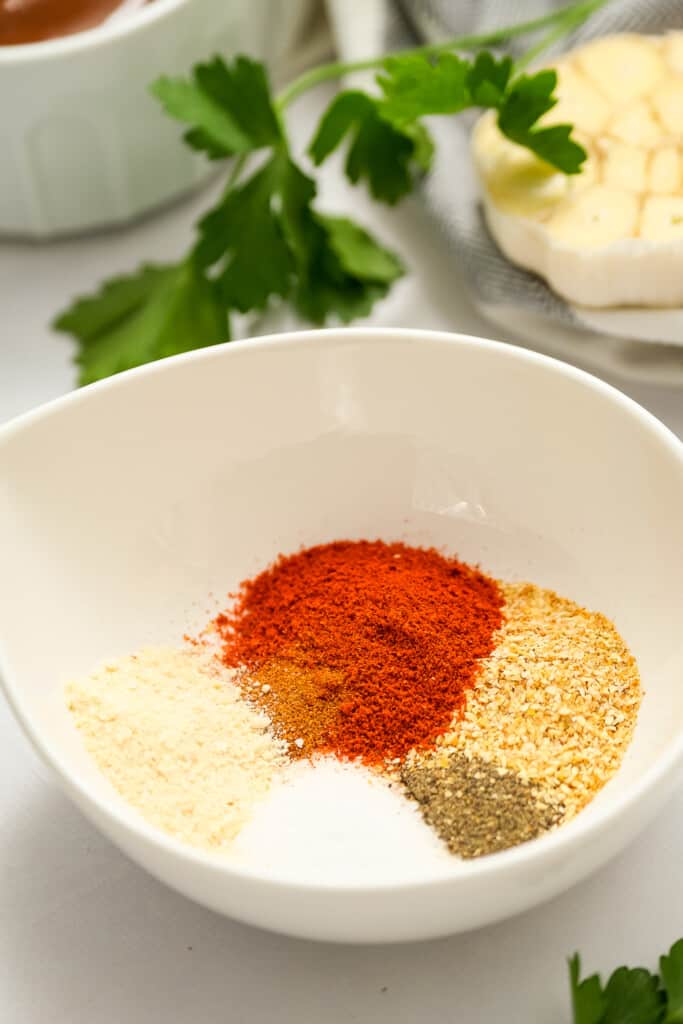 White bowl with seasonings for chicken legs