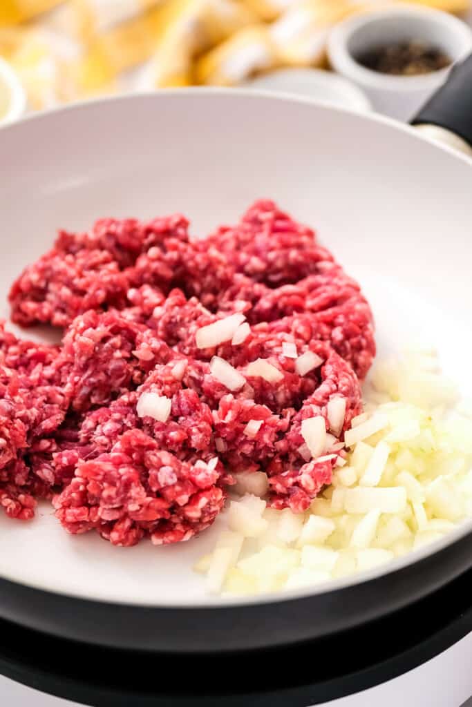 Skillet with ground beef and onions in it