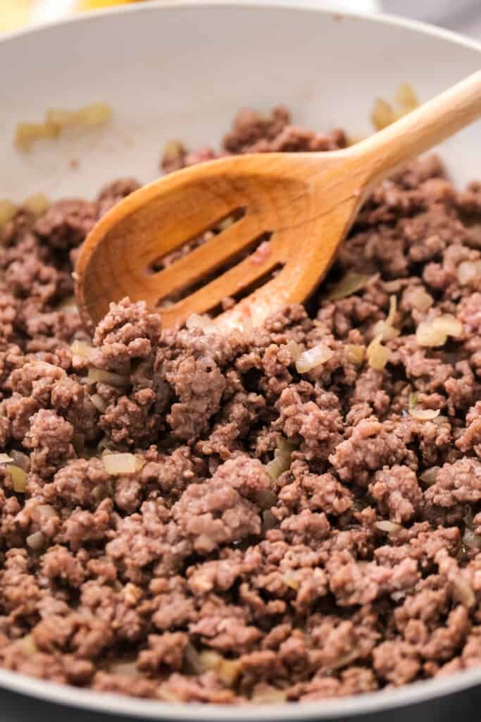 Skillet with cooked ground beef and onions