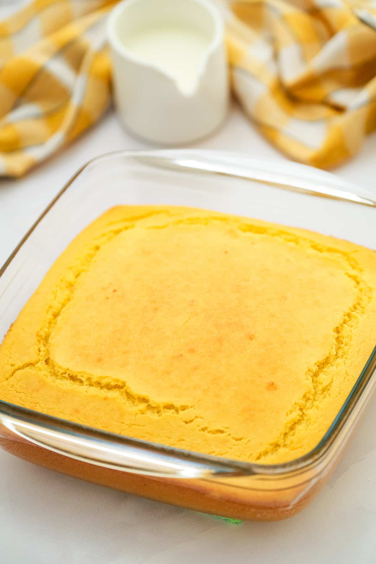 Square glass baking dish with baked cornbread in it.