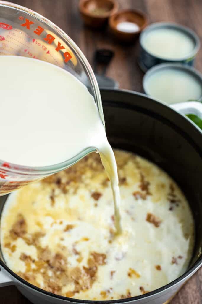 Pouring milk into a soup base in stockpot