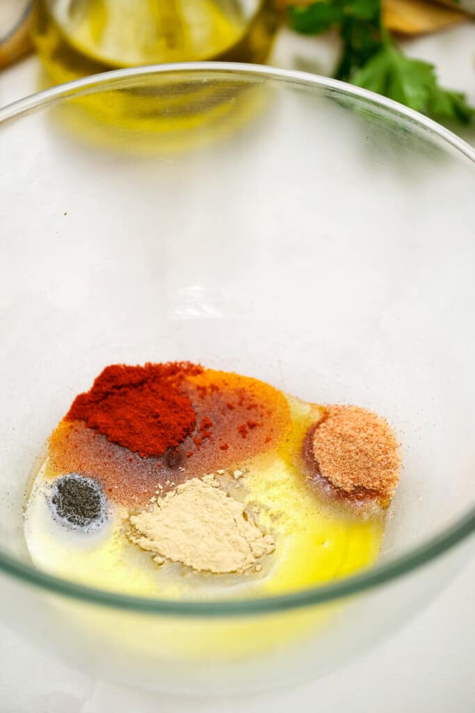 Olive oil and seasonings in glass bowl