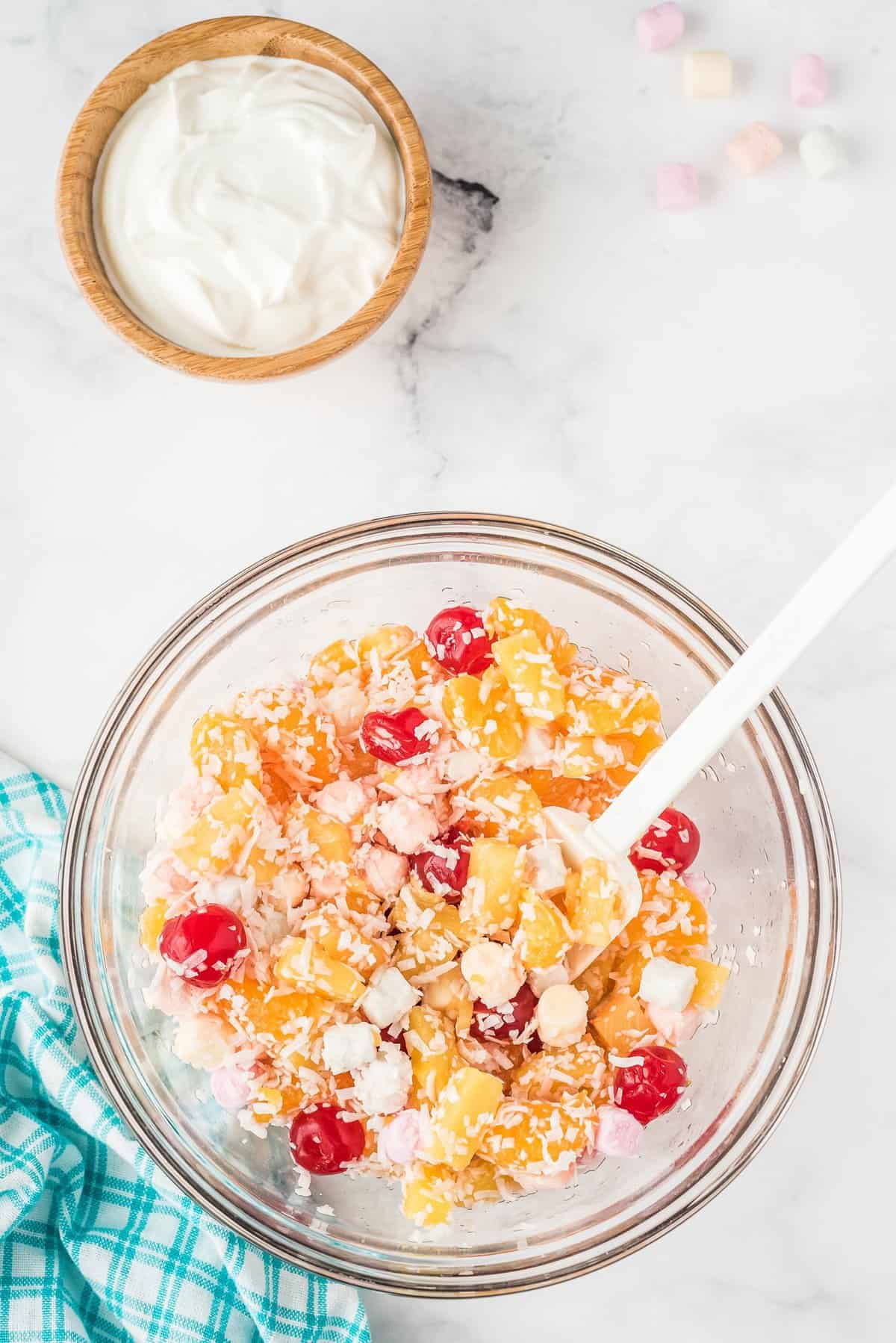 Overhead image of glass bowl with ingredients for Ambrosia salad after mixing