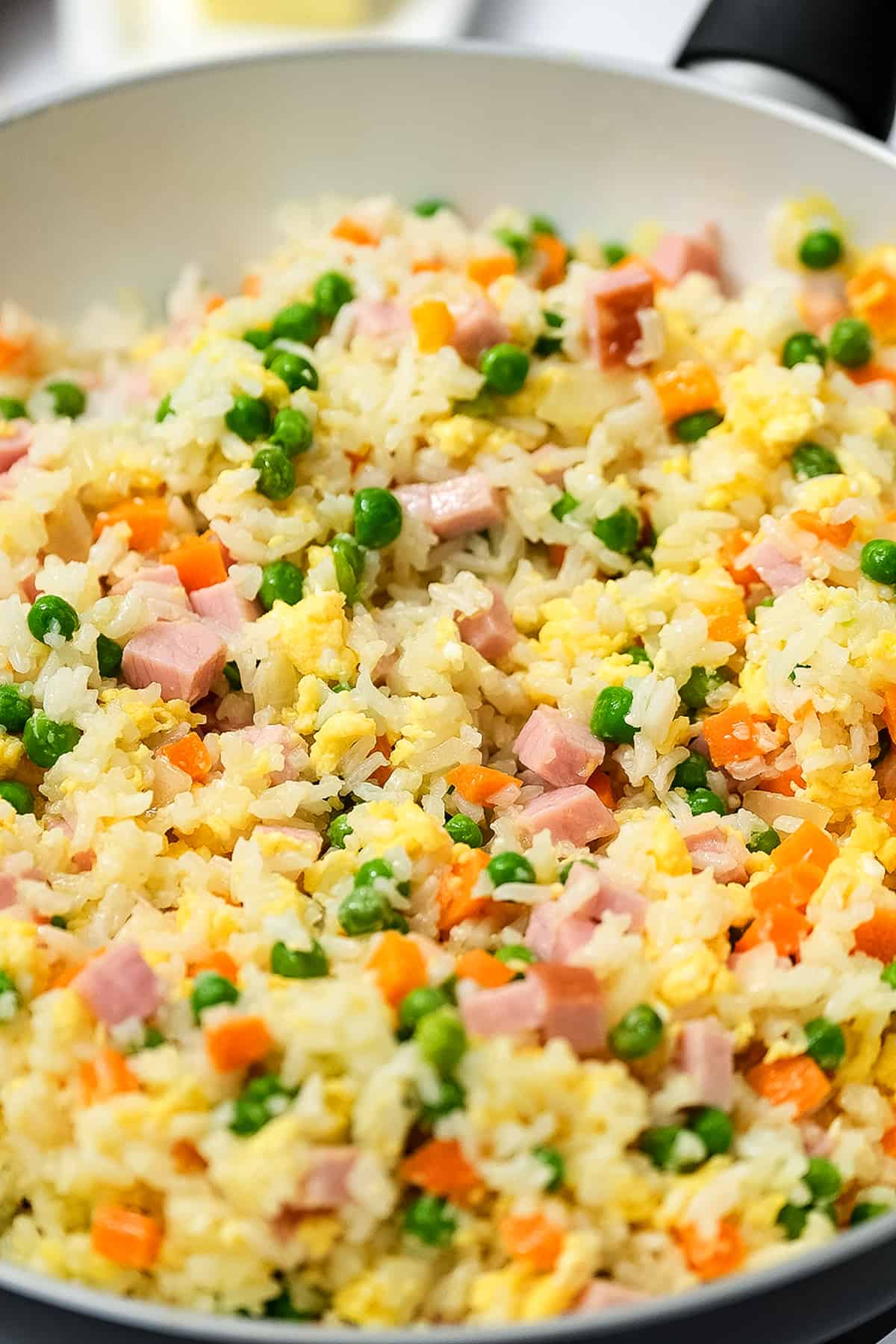 Stirring ham fried rice together in skillet