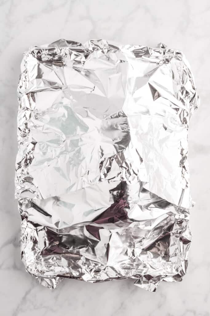 Overhead image of foil covered ham on sheet pan