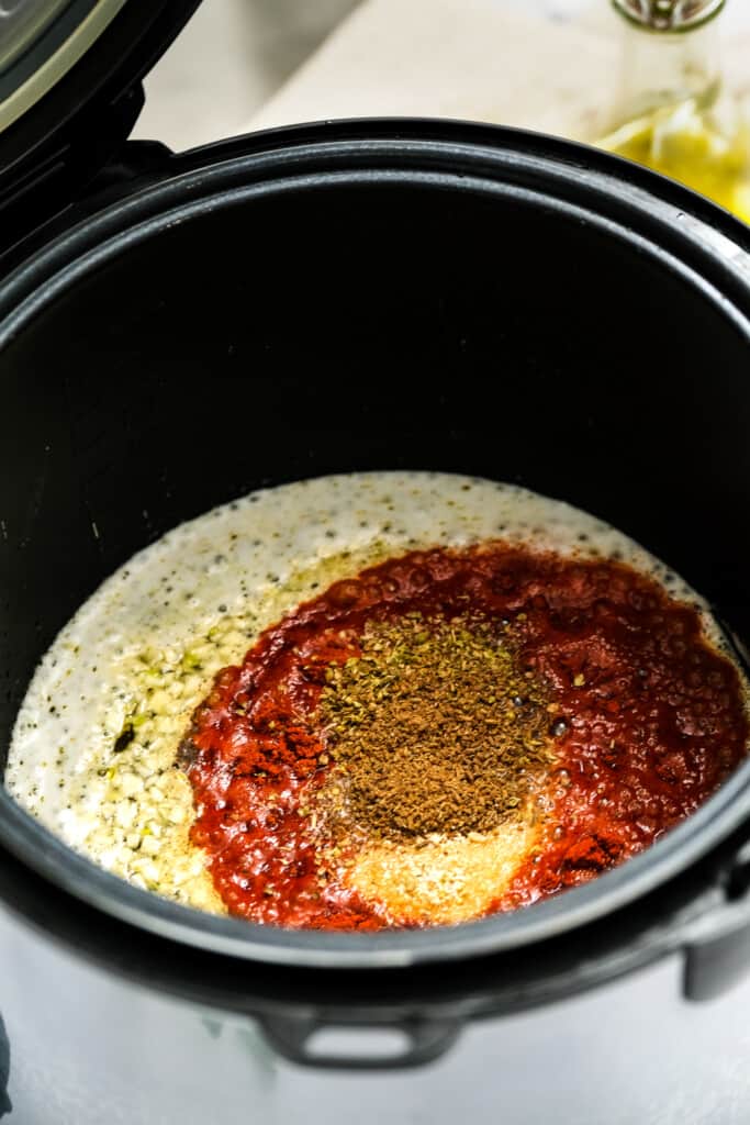 Instant Pot with beer and seasonings in it for carnitas