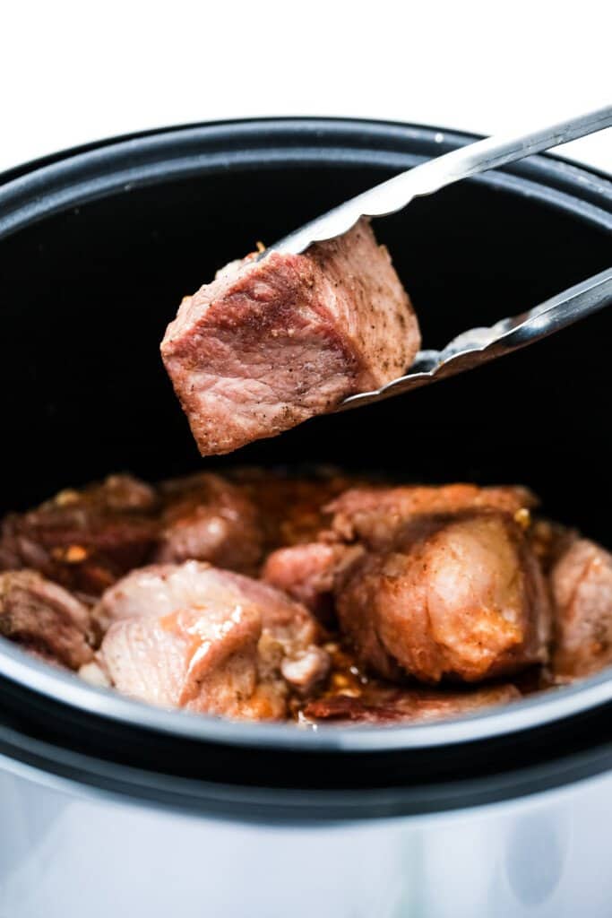 Putting pork shoulder into Instant Pot to make Carnitas