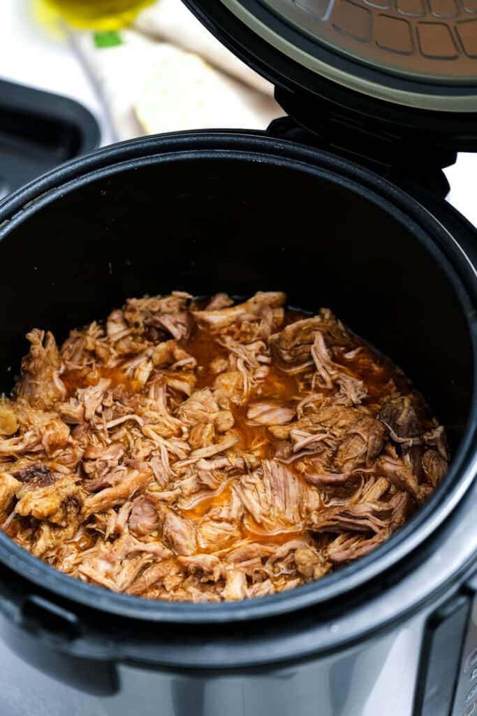 Shredded pork carnitas meat in pressure cooker