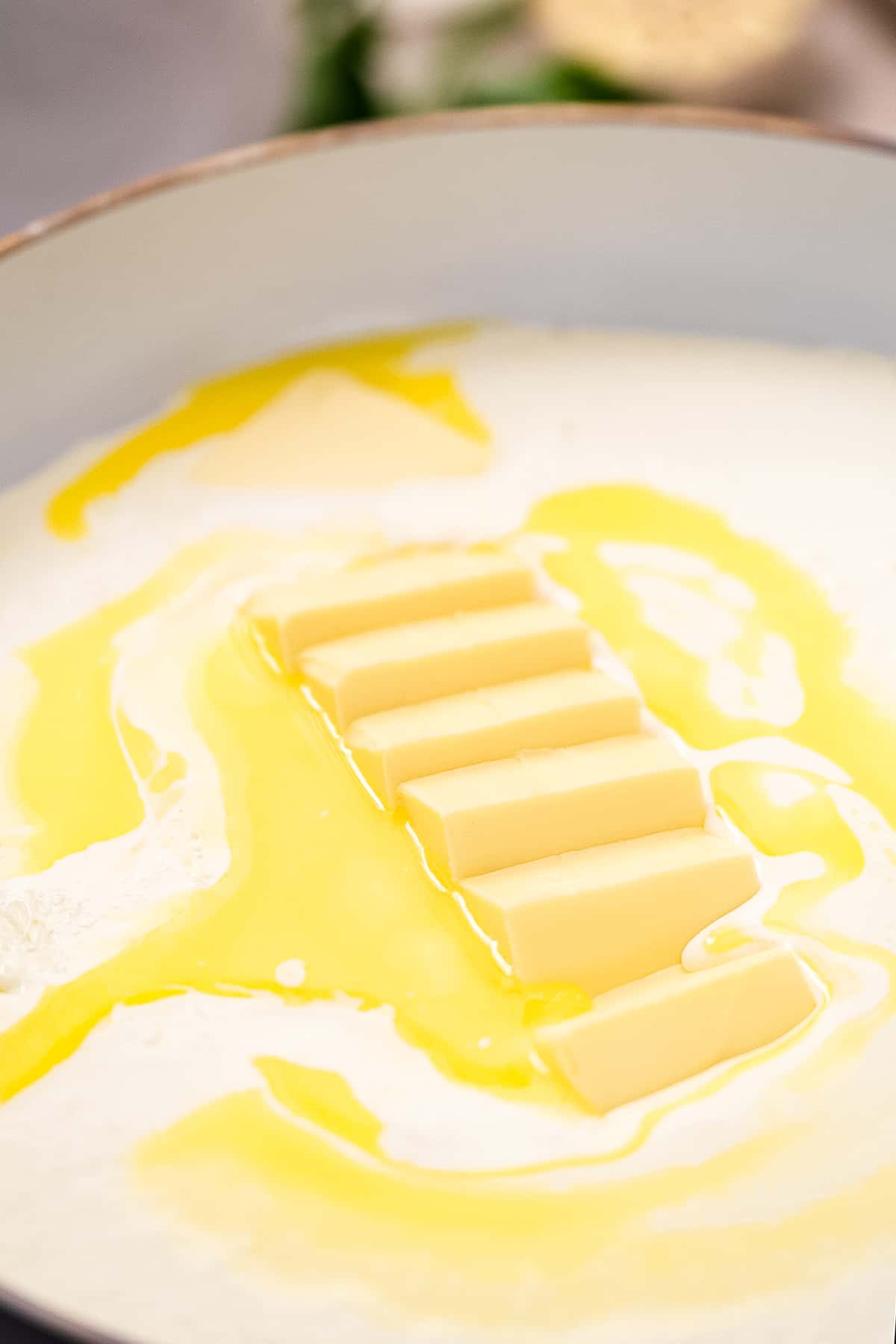 Butter melting in cream in skillet