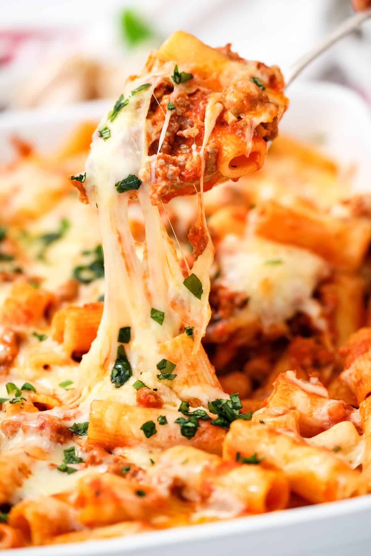 Scooping Rigatoni out of casserole dish with spoon