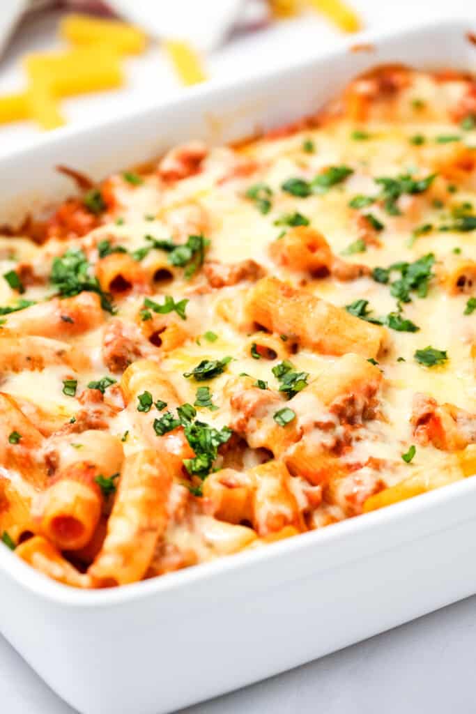 White casserole dish with baked rigatoni in it