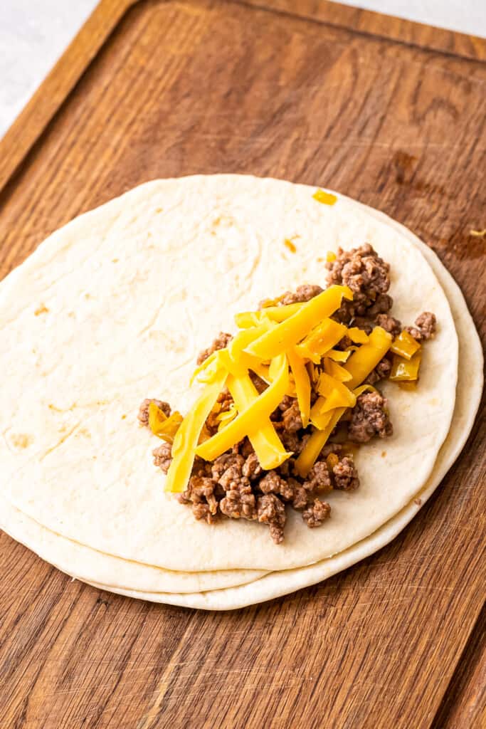 Soft tortilla with ground beef, chiles and cheese on top