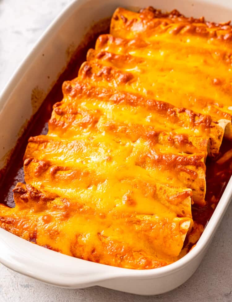 White casserole dish with ground beef enchiladas