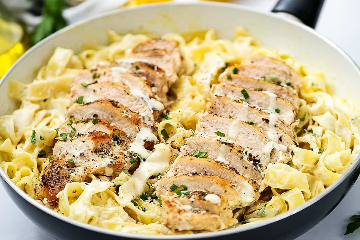 Skillet with fettucine alfredo and chicken breasts