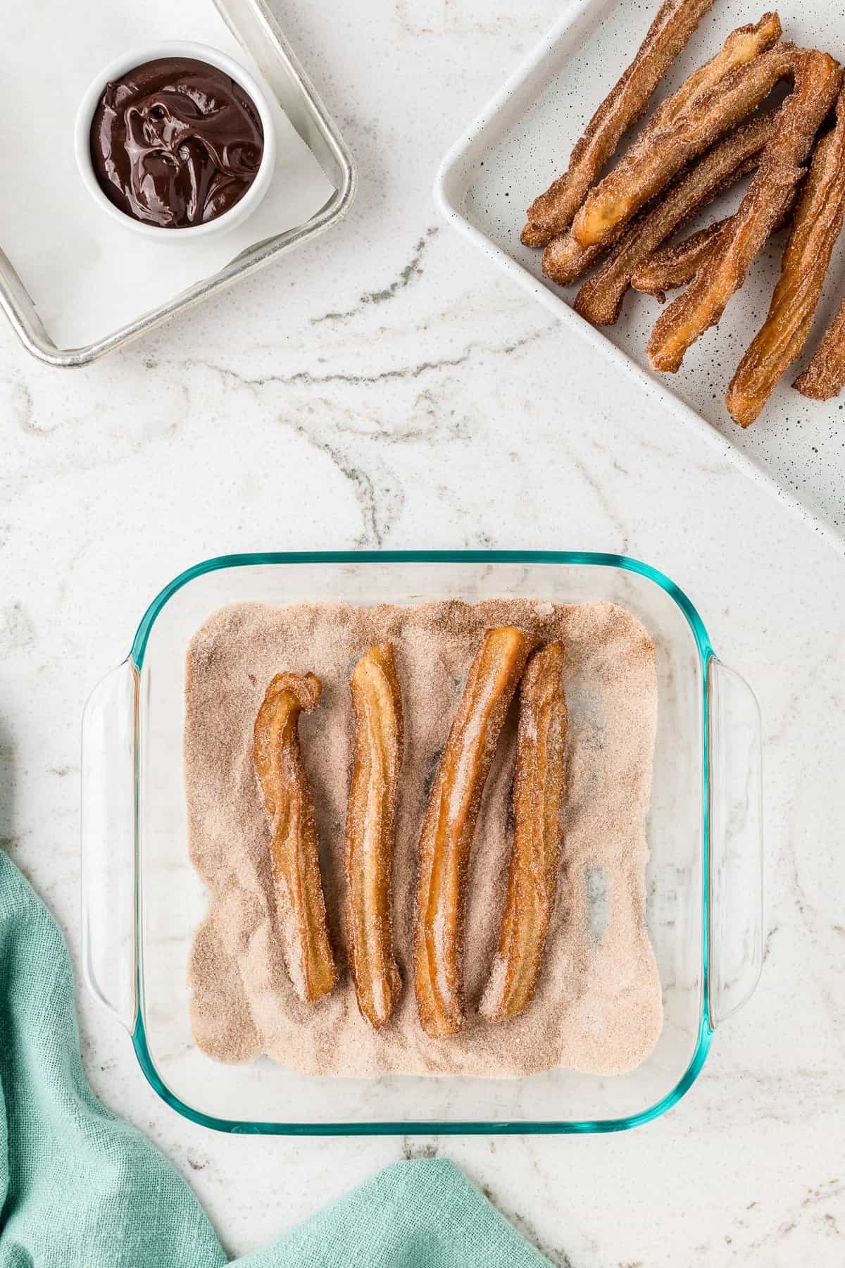 Overhead image of cinnamon sugar in dish with churros