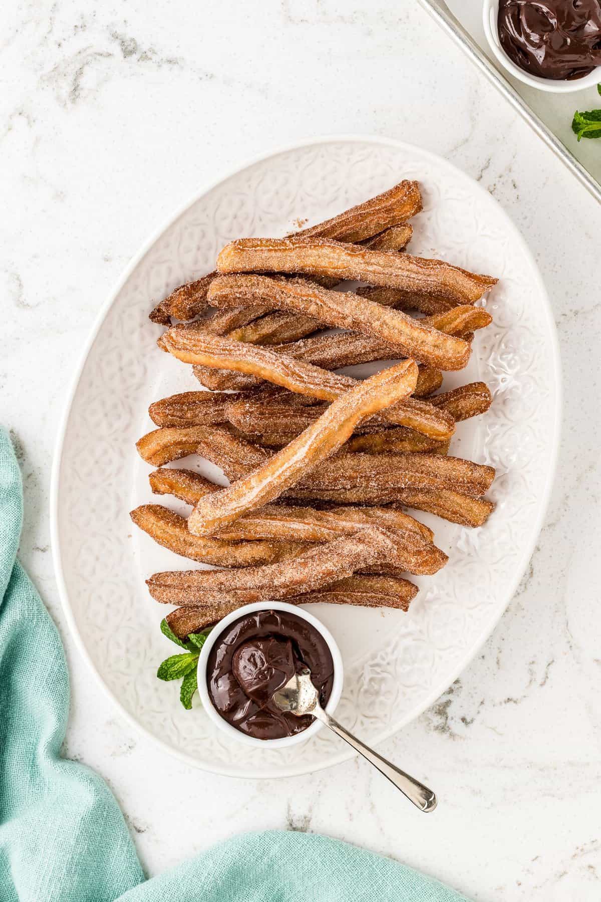 Overhead image of churros on baking dish with chocolate sauce