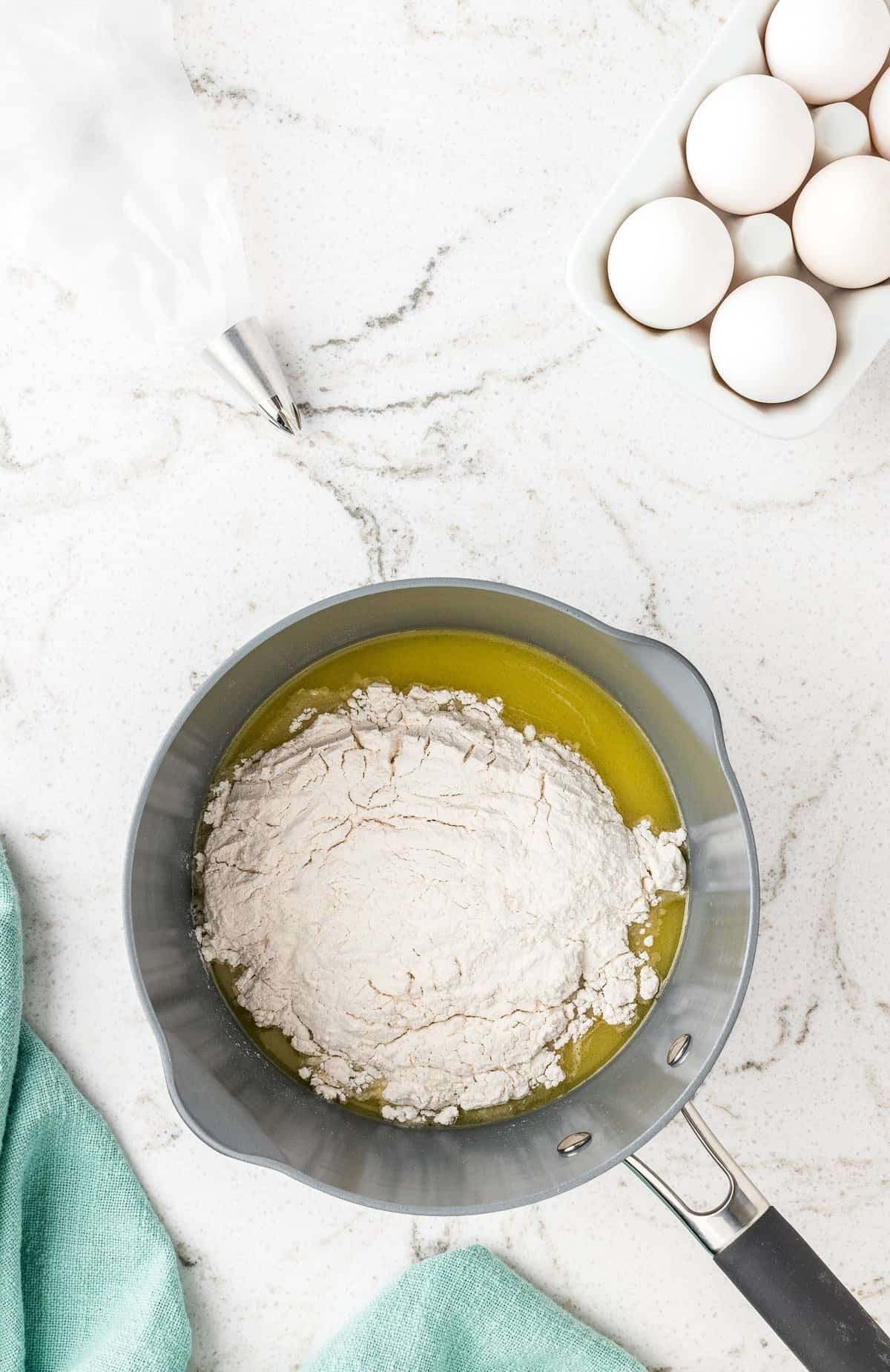 Overhead image of saucepan with melted butter and flour for churro dough