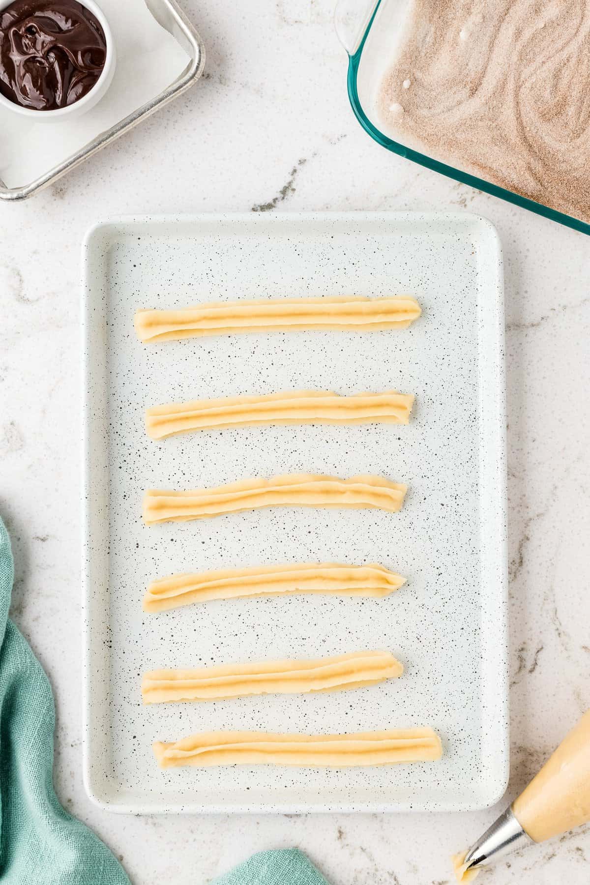 Overhead image of raw churros on baking sheet
