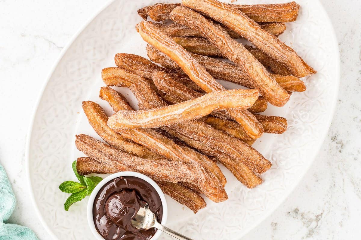 Overhead image of fried churros on white dish