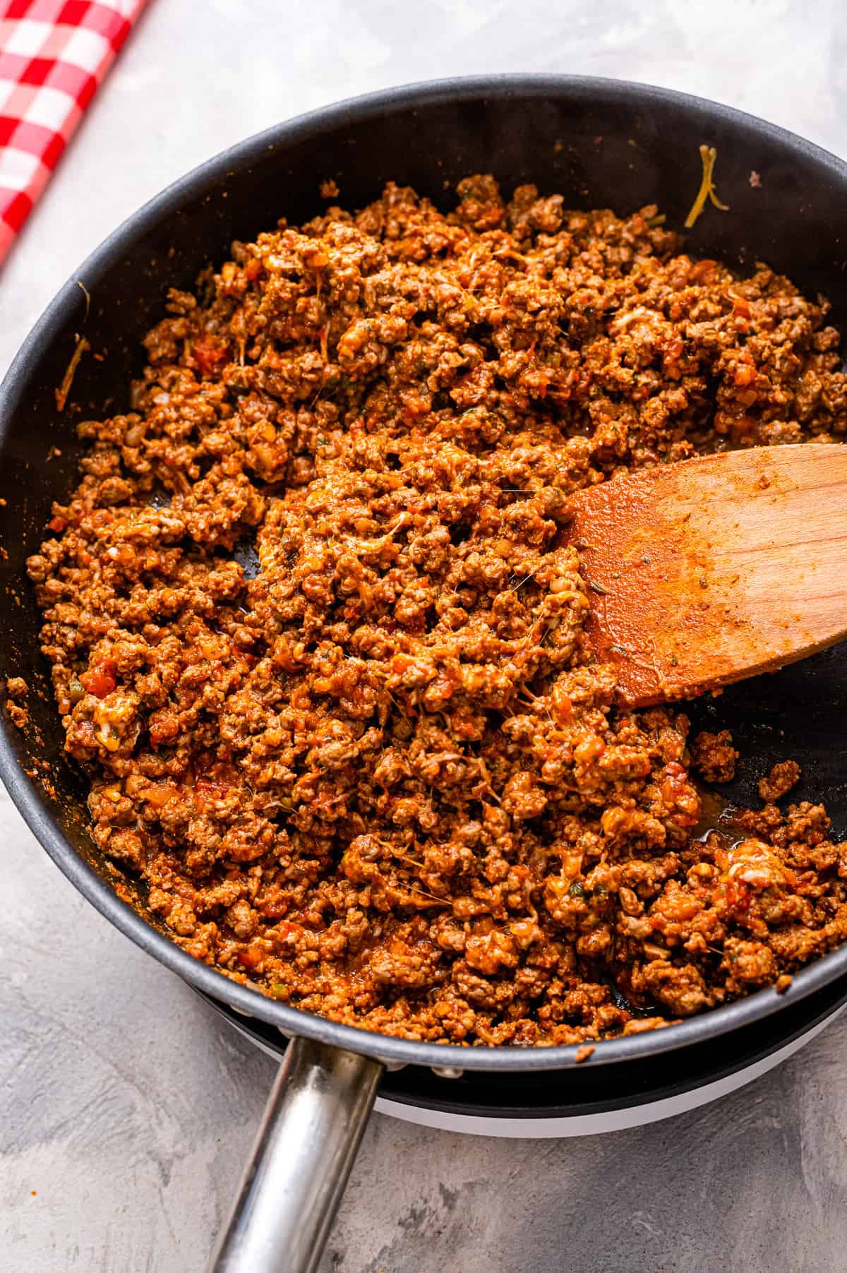 Skillet with taco meat in it and wooden spatula