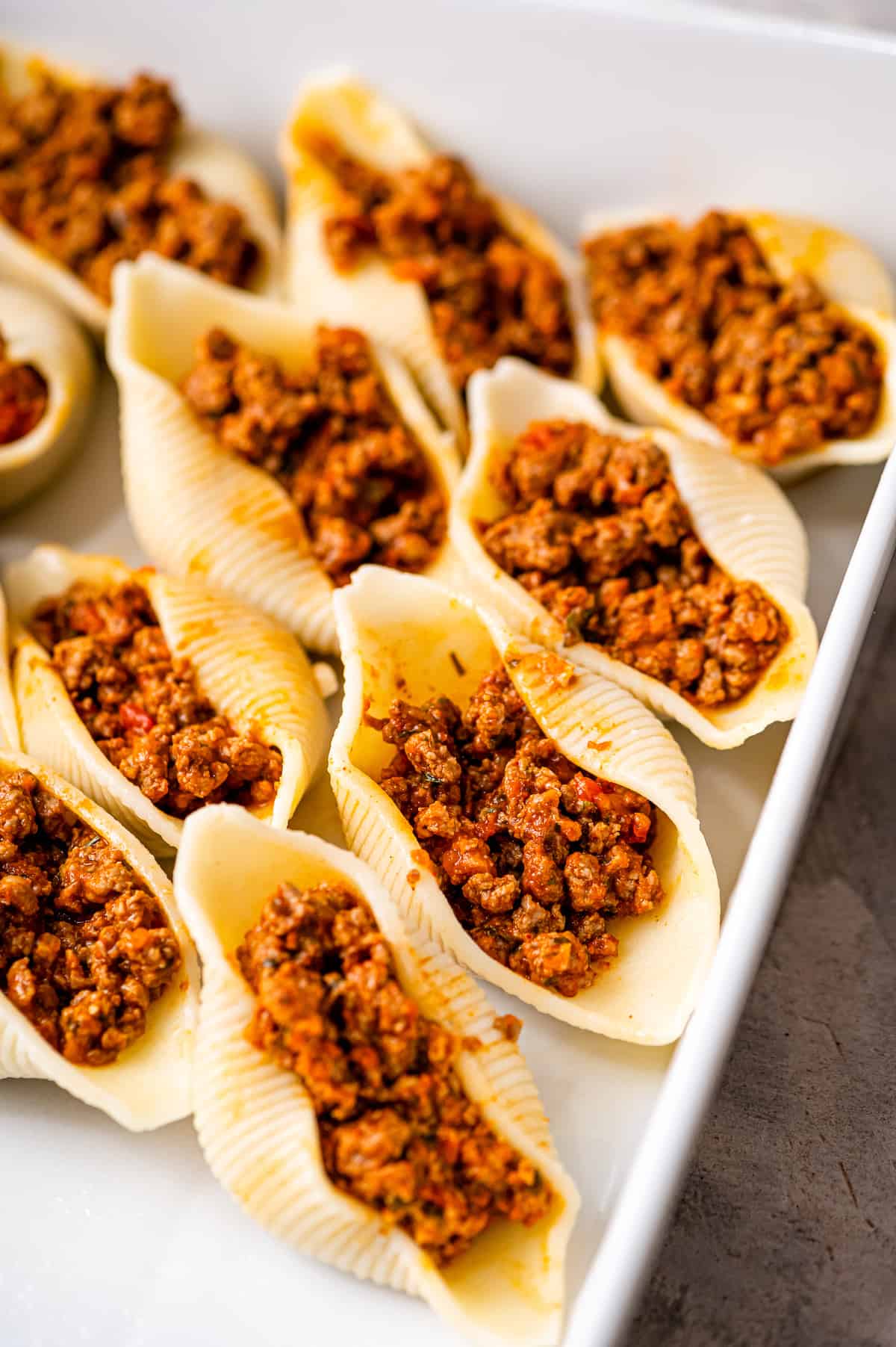 Casserole dish with jumbo pasta shells filled with taco meat