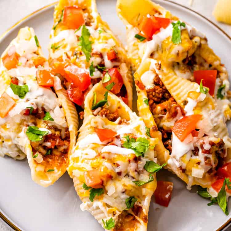 White plate with taco stuffed shells and toppings